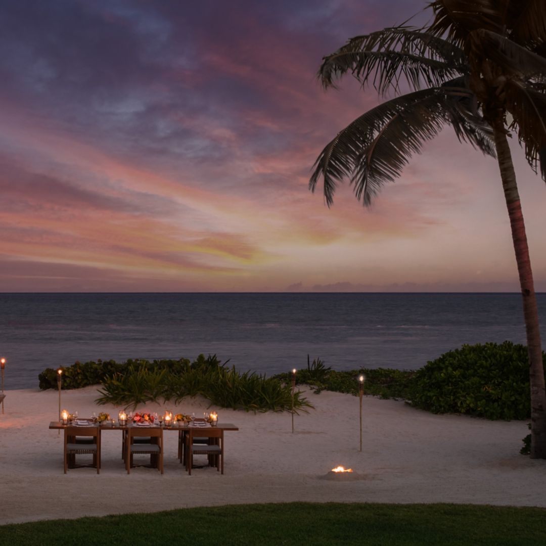 Beachfront dinner set up at sunset.